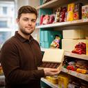 Jermel Boertien checking boxed chocolates and snack stock in the Wigan sweet shop