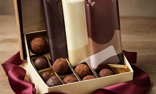 Chocolate lovers gift box with wrapped bars, truffles and a ribbon on a shop table