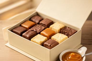 Milk chocolate and caramel pieces in a neat gift box beside a small caramel dish