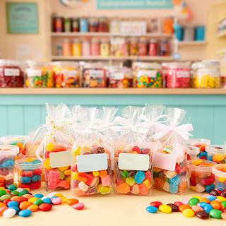 Individually labelled school-ready party bags arranged beside a colourful sweet counter