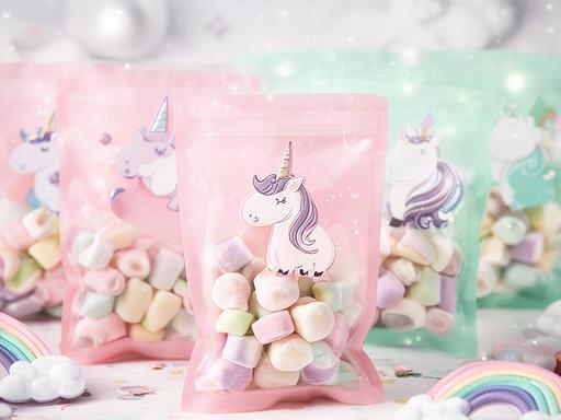 Unicorn-themed pink and mint sweet bags arranged for a children's party